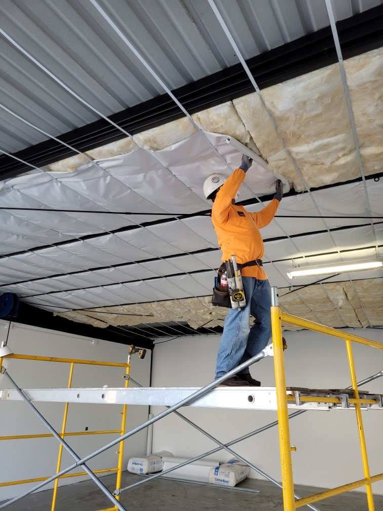 Technician installing foil insulation in the ceiling