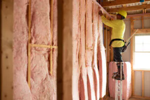 Worker installing insulation in building